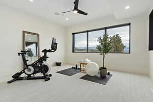 Workout area featuring ceiling fan and light colored carpet