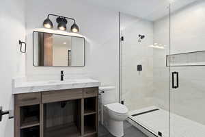 Bathroom featuring vanity, toilet, and walk in shower