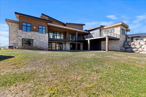 Rear view of house featuring a yard