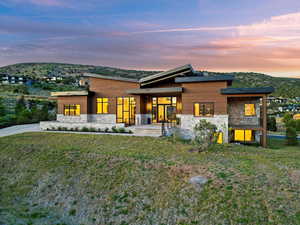 Contemporary house with stone siding and a front yard