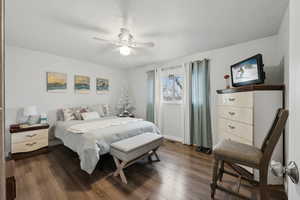 Bedroom with ceiling fan and dark wood-type flooring