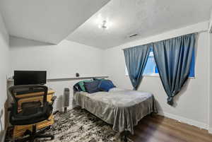 Bedroom featuring wood-type flooring and a textured ceiling