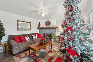 Living room featuring a tile fireplace, ceiling fan, and hardwood / wood-style floors