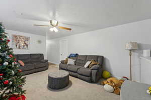 Carpeted living room with ceiling fan