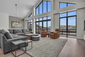 Living room featuring hardwood / wood-style flooring and a towering ceiling