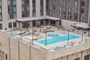 View of pool featuring a community hot tub and a patio area