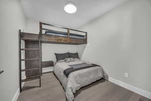 Bedroom with lofted ceiling and wood-type flooring