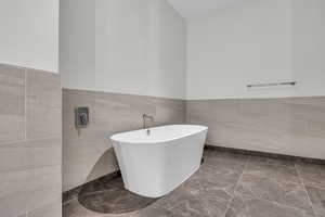 Bathroom featuring tile walls and a tub