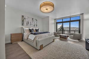 Bedroom with hardwood / wood-style floors and a wall of windows