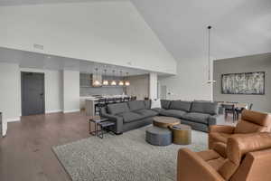 Living room with a towering ceiling and hardwood / wood-style flooring