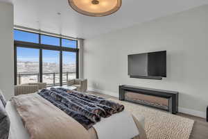 Bedroom with a mountain view, wood-type flooring, and a wall of windows