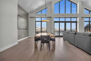 Dining space featuring a towering ceiling and wood-type flooring