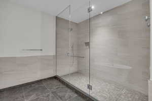 Bathroom featuring an enclosed shower and tile walls