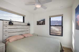 Bedroom featuring hardwood / wood-style flooring, multiple windows, and ceiling fan