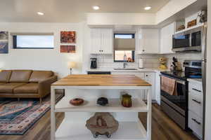 Kitchen with a healthy amount of sunlight, sink, white cabinets, and stainless steel appliances