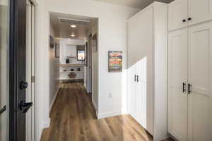 Hall with wood-type flooring and sink