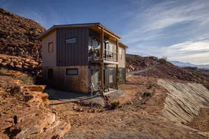 View of property exterior with a mountain view and a balcony