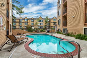 View of pool with a grill and a patio area