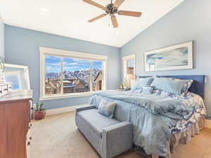 Bedroom with light colored carpet, vaulted ceiling, and ceiling fan