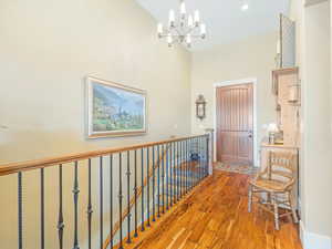 Hall with a chandelier and hardwood / wood-style flooring