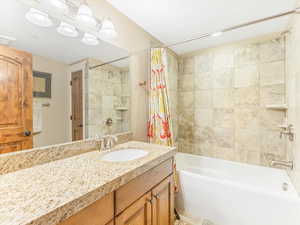 Bathroom featuring shower / bath combo with shower curtain and vanity