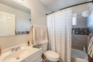 Full bathroom featuring vanity, toilet, and shower / bath combo with shower curtain