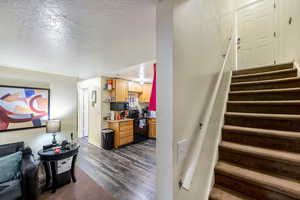 Stairway featuring hardwood / wood-style floors and a textured ceiling