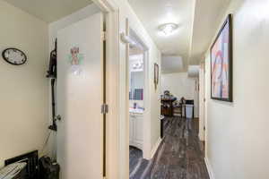 Corridor with sink, dark wood-type flooring, and a textured ceiling