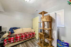 Interior space with hardwood / wood-style floors and a textured ceiling