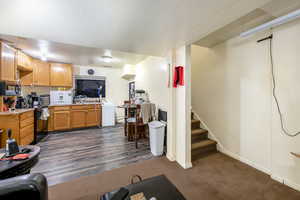 Kitchen featuring a textured ceiling, dark hardwood / wood-style floors, and black appliances