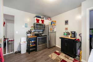 Kitchen featuring dark hardwood / wood-style flooring, a textured ceiling, and appliances with stainless steel finishes