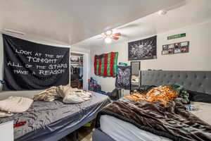 Bedroom featuring ceiling fan, a closet, a textured ceiling, and hardwood / wood-style flooring