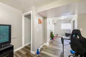 Office space with hardwood / wood-style flooring and a textured ceiling