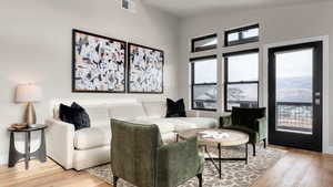 Living room with vaulted ceiling and light hardwood / wood-style flooring