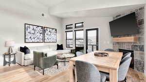 Interior space featuring a fireplace, lofted ceiling, and light wood-type flooring