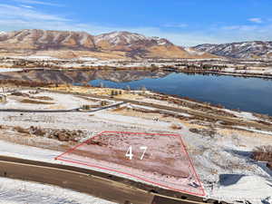 Snowy aerial view featuring a water and mountain view