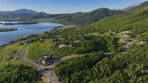 Aerial overview of property's location featuring a water and mountain view and a forest