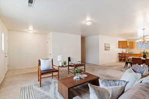 Living room with a chandelier and light colored carpet