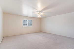 Unfurnished room featuring ceiling fan and light colored carpet