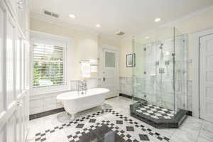 Bathroom featuring crown molding and plus walk in shower