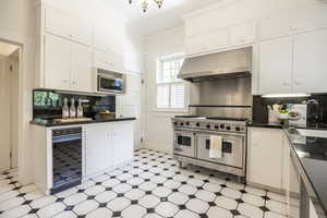 Kitchen with white cabinetry, sink, decorative backsplash, appliances with stainless steel finishes, and ornamental molding