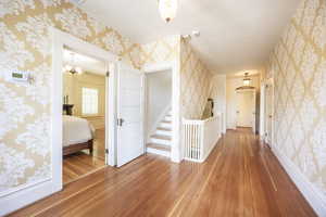 Hall with hardwood / wood-style flooring and a chandelier