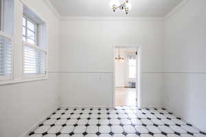 Spare room with radiator, crown molding, and a chandelier