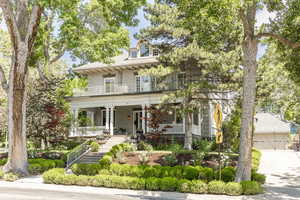 View of front of home featuring covered porch, a balcony, and a garage