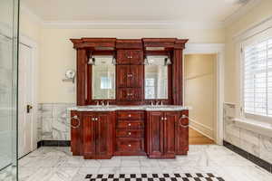 Bathroom featuring vanity, a wealth of natural light, and ornamental molding