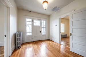 Entryway with light wood-type flooring and radiator