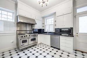 Kitchen with appliances with stainless steel finishes, white cabinetry, and sink