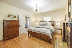 Bedroom featuring light hardwood / wood-style floors and a notable chandelier