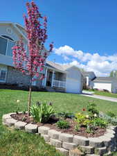 View of front of property with a garage, covered porch, and a front yard