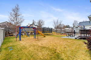 View of yard with a playground, a patio, and a trampoline